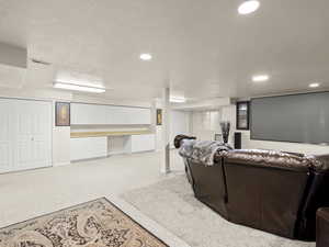Home theater featuring light carpet, built in study area, and recessed lighting