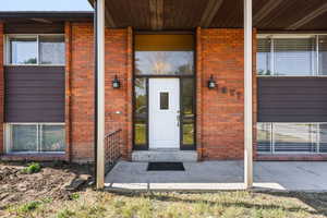 Property entrance featuring brick siding