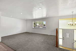 Carpeted entryway with a chandelier and recessed lighting