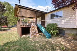 View of jungle gym with a yard and a deck