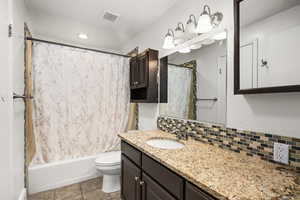Bathroom with vanity, backsplash, shower / bath combo with shower curtain, tile patterned floors, and recessed lighting