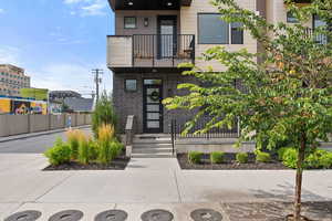 View of front of house with a balcony and brick siding
