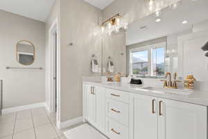 Bathroom featuring double vanity, tile patterned floors, and recessed lighting