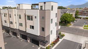 View of building exterior featuring a garage, a mountain view, and driveway