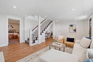 Living area featuring stairway, light wood-style floors, and recessed lighting