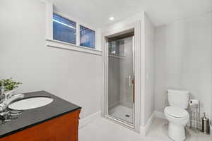 Bathroom featuring a stall shower, vanity, and tile patterned flooring