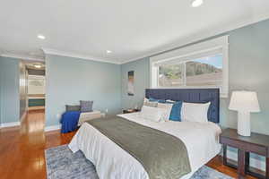 Bedroom with ornamental molding, wood finished floors, and recessed lighting