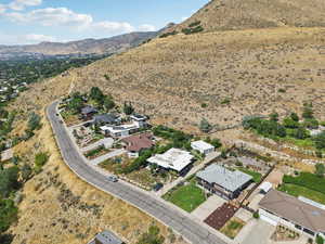 Aerial overview of property's location featuring mountains and nearby suburban area