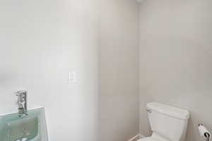 Half bath featuring toilet and a sink