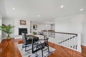 Dining room with a glass covered fireplace, crown molding, recessed lighting, and hardwood / wood-style flooring