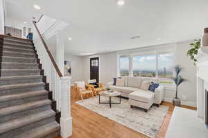 Living area featuring stairway, recessed lighting, light wood-style flooring, and a fireplace