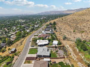 Aerial view of property and surrounding area with a mountainous background and nearby suburban area