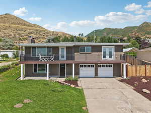 View of front property featuring a mountain view, driveway, a chimney, and an attached garage