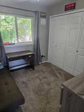Bedroom with carpet flooring, a closet, and baseboard heating
