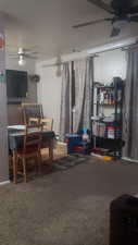 Carpeted living room featuring ceiling fan