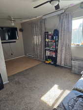 Carpeted bedroom with a ceiling fan