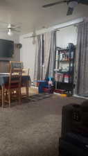 Living room featuring ceiling fan and carpet