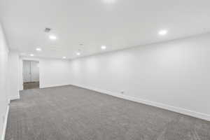 Carpeted empty room with recessed lighting