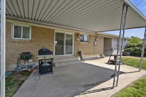 View of patio featuring entry steps, area for grilling, and an attached carport