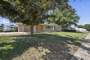 View of front of home with driveway, brick siding, and a front yard