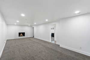 Unfurnished living room with recessed lighting, a fireplace, and carpet