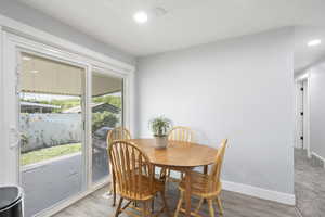 Dining space with light wood-style floors and recessed lighting