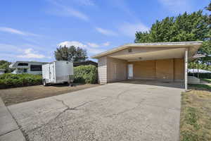 View of front of property with concrete driveway, brick siding, and a carport