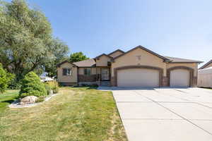 Single story home featuring a garage, stucco siding, a front lawn, concrete driveway, and brick siding