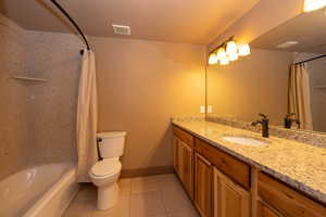 Full bath featuring tile patterned floors, vanity, and shower / tub combo