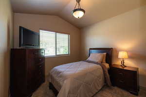 Carpeted bedroom with vaulted ceiling