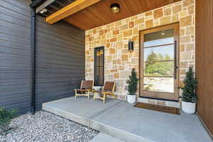 Entrance to property with stone siding and a porch
