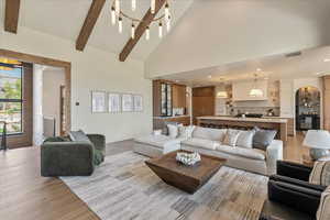 Living area featuring light wood-type flooring, high vaulted ceiling, recessed lighting, beamed ceiling, and arched walkways