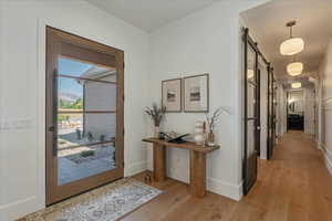Entryway with a barn door and light wood-style floors
