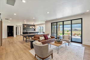 Living area with light wood-style floors and recessed lighting