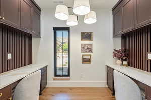 Office space featuring light wood-style flooring and built in desk