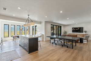 Kitchen with light wood-style floors, a center island, recessed lighting, light countertops, and pendant lighting