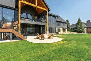 Back of house featuring a patio, a lawn, and stairs