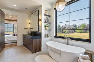 Bathroom with vanity, a freestanding tub, ensuite bathroom, and recessed lighting