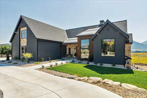 View of front facade featuring stone siding, a standing seam roof, a metal roof, and a front yard