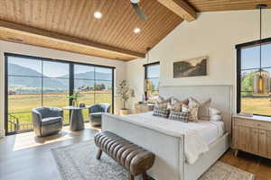 Bedroom with a mountain view, wood ceiling, dark wood-style flooring, access to exterior, and recessed lighting