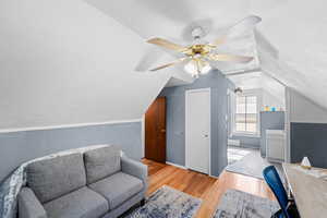 Living area with wood finished floors, lofted ceiling, and ceiling fan
