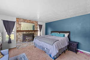 Primary Bedroom featuring a stone fireplace