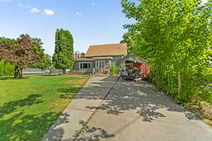 View of front facade featuring a front lawn, concrete driveway, and a shingled roof