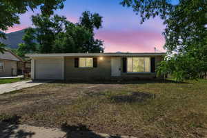 Ranch-style house featuring concrete driveway and a garage