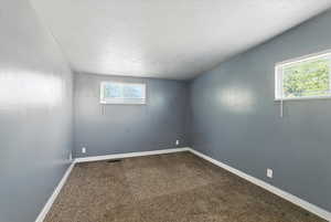 Bedroom with plenty of natural light and dark colored carpet