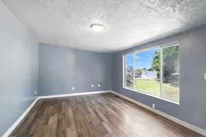 Living room with dark wood finished floors and a textured ceiling
