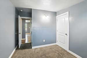 Bedroom with carpet and a textured ceiling