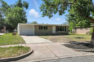 Single story home featuring an attached garage and driveway
