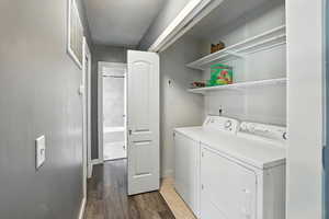 Laundry area featuring washing machine and dryer and wood finished floors