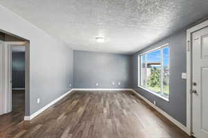 Living room with dark wood-style floors and a textured ceiling
